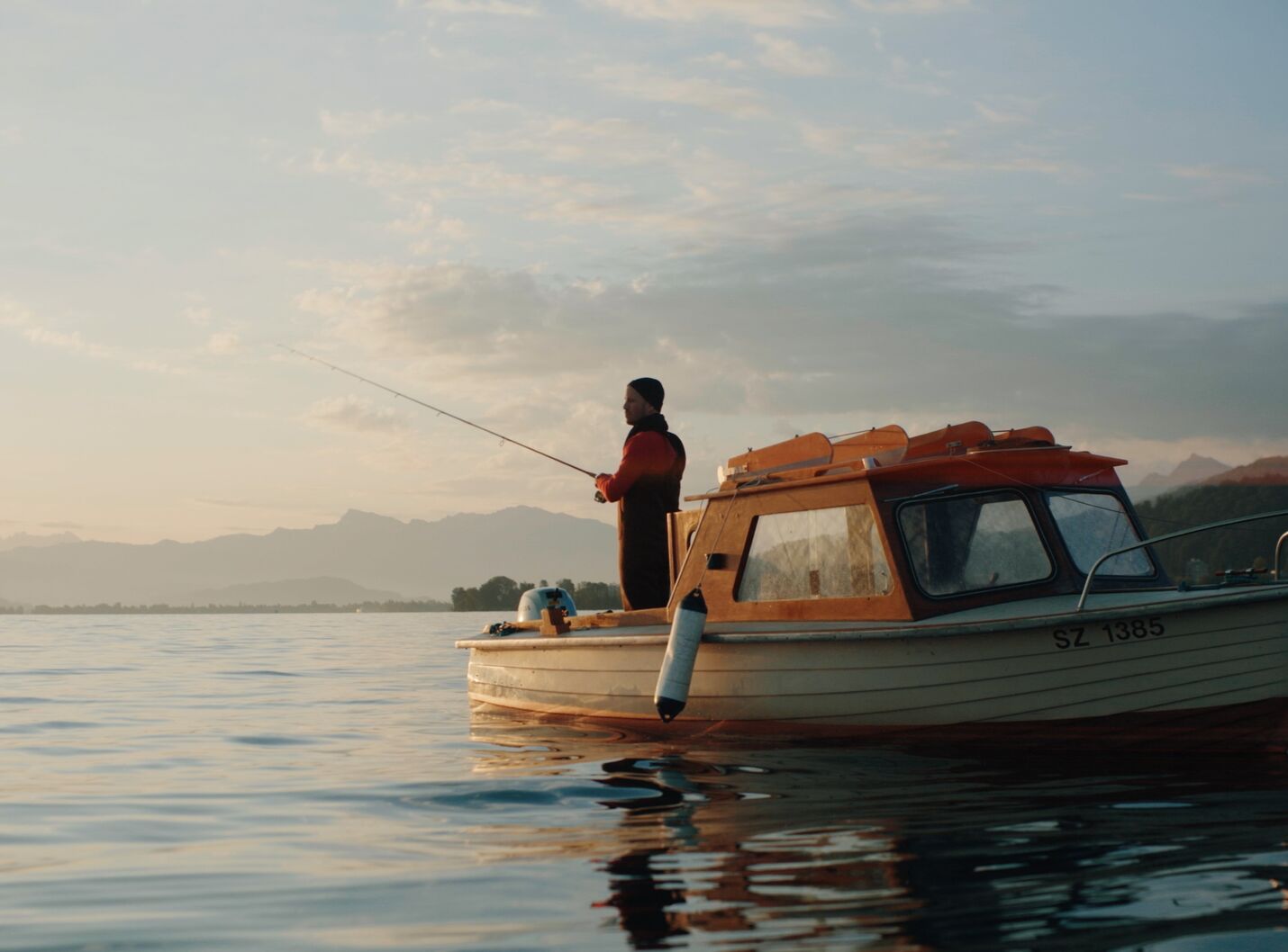 Schauspieler Philippe Graff als Fischer auf dem Zürichsee bei Sonnenaufgang – Szene aus der modularen Raiffeisen Zürisee Storyworld von CORPMEDIA.