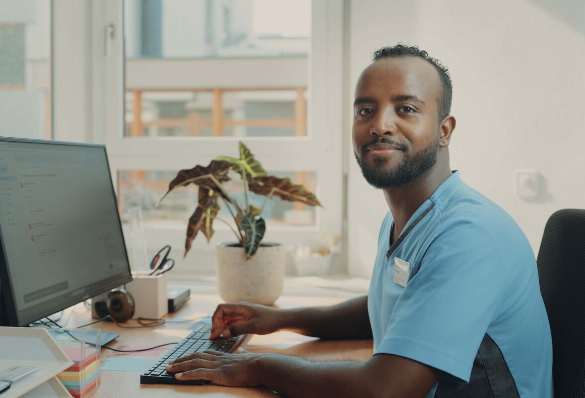Filmstill aus der SRK Kanton Zürich Erfolgsstory – Protagonist Hassan als Pflegehelfer am Arbeitsplatz, seine Geschichte vom schwierigen Schulstart zum erfolgreichen Berufseinstieg, gecoacht und produziert von CORPMEDIA.