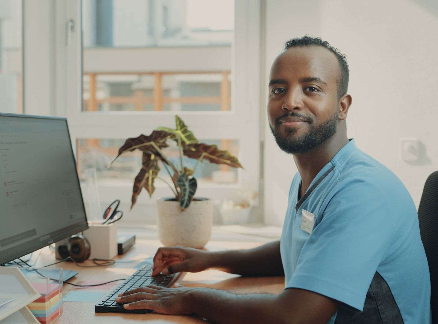 Filmstill aus der SRK Kanton Zürich Erfolgsstory – Protagonist Hassan als Pflegehelfer am Arbeitsplatz, seine Geschichte vom schwierigen Schulstart zum erfolgreichen Berufseinstieg, gecoacht und produziert von CORPMEDIA.