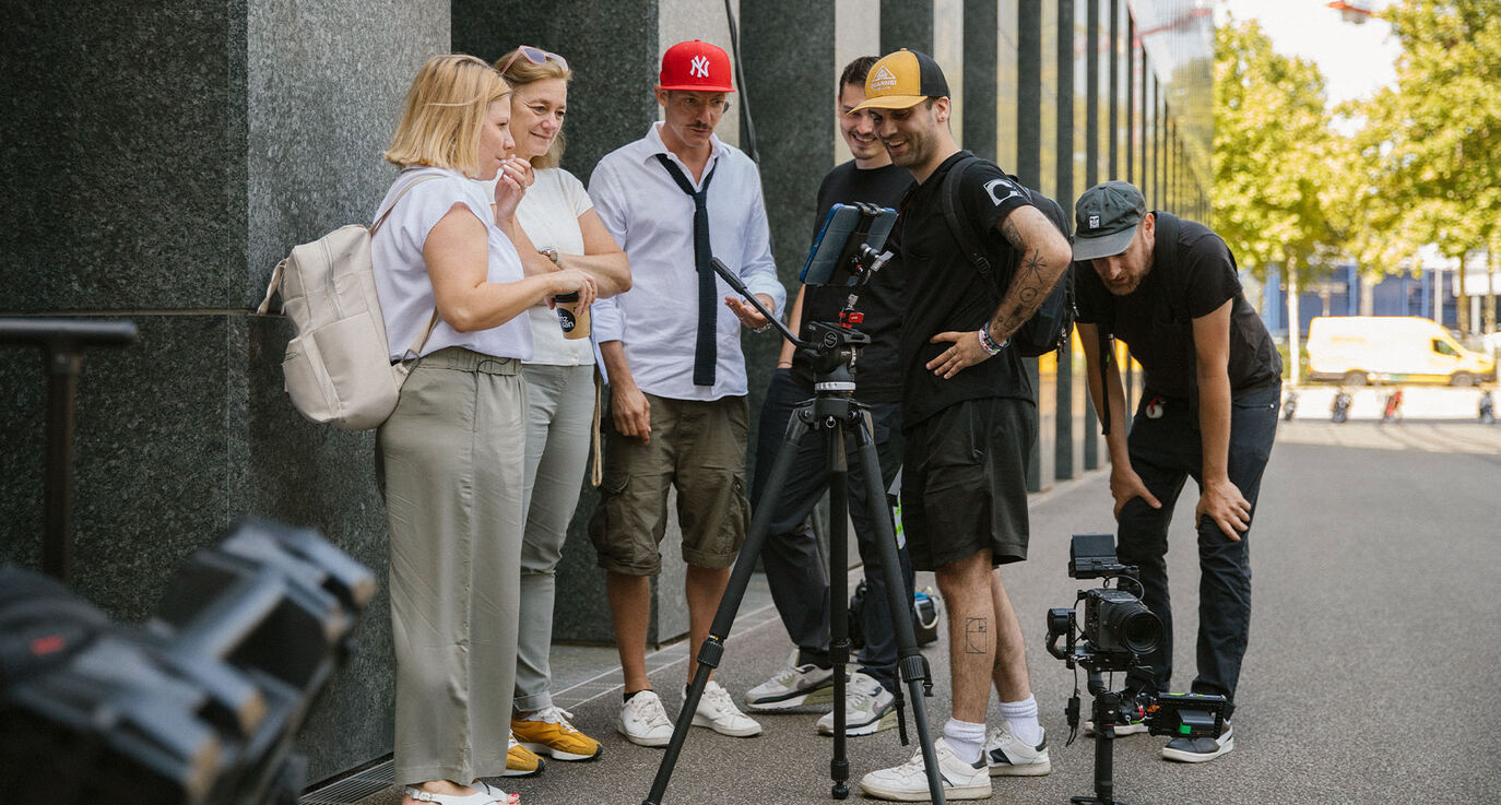 Susanne Zihlmann (SRK Kanton Zürich), Manuela Frenjo und die CORPMEDIA Crew beim Footage Review auf dem Set in Oerlikon – Corporate Influencer Portrait Produktion, alle sichtlich begeistert von den Aufnahmen.
