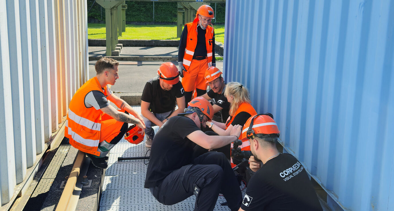 CORPMEDIA Filmcrew versteckt sich zwischen Containern um den SBB Bahnstrom Protagonisten nicht ins Bild zu stehen – Behind the Scenes des Employer Branding Films für SBB CFF FFS, maximale Authentizität vor der Kamera.