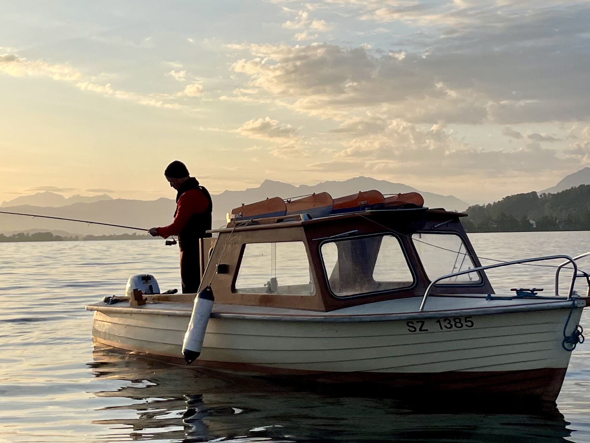 Filmstill der Einstiegsszene des Raiffeisen Linker Zürichsee Werbespots – Schauspieler Philippe Graff als Fischer beim Sonnenaufgang auf dem Zürichsee, gedreht von CORPMEDIA an einem 18-Stunden-Drehtag für die modulare Storyworld.