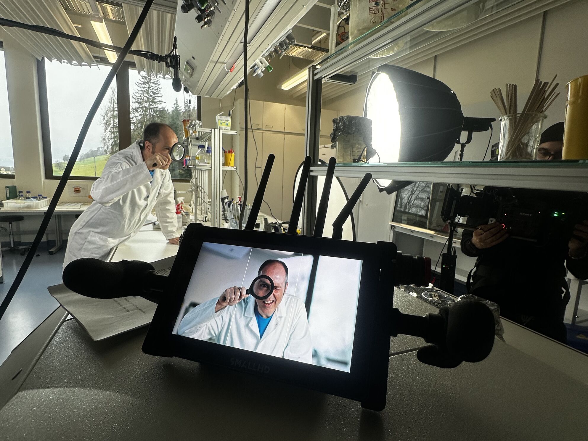 Lars, Leiter Mikrobiologe der ZHAW Wädenswil, beim Filmdreh mit Detektiv-Lupe – Behind the Scenes der CORPMEDIA Recruiting Storyworld, bei der Protagonist:innen persönlich gecoacht und am Set begleitet wurden.