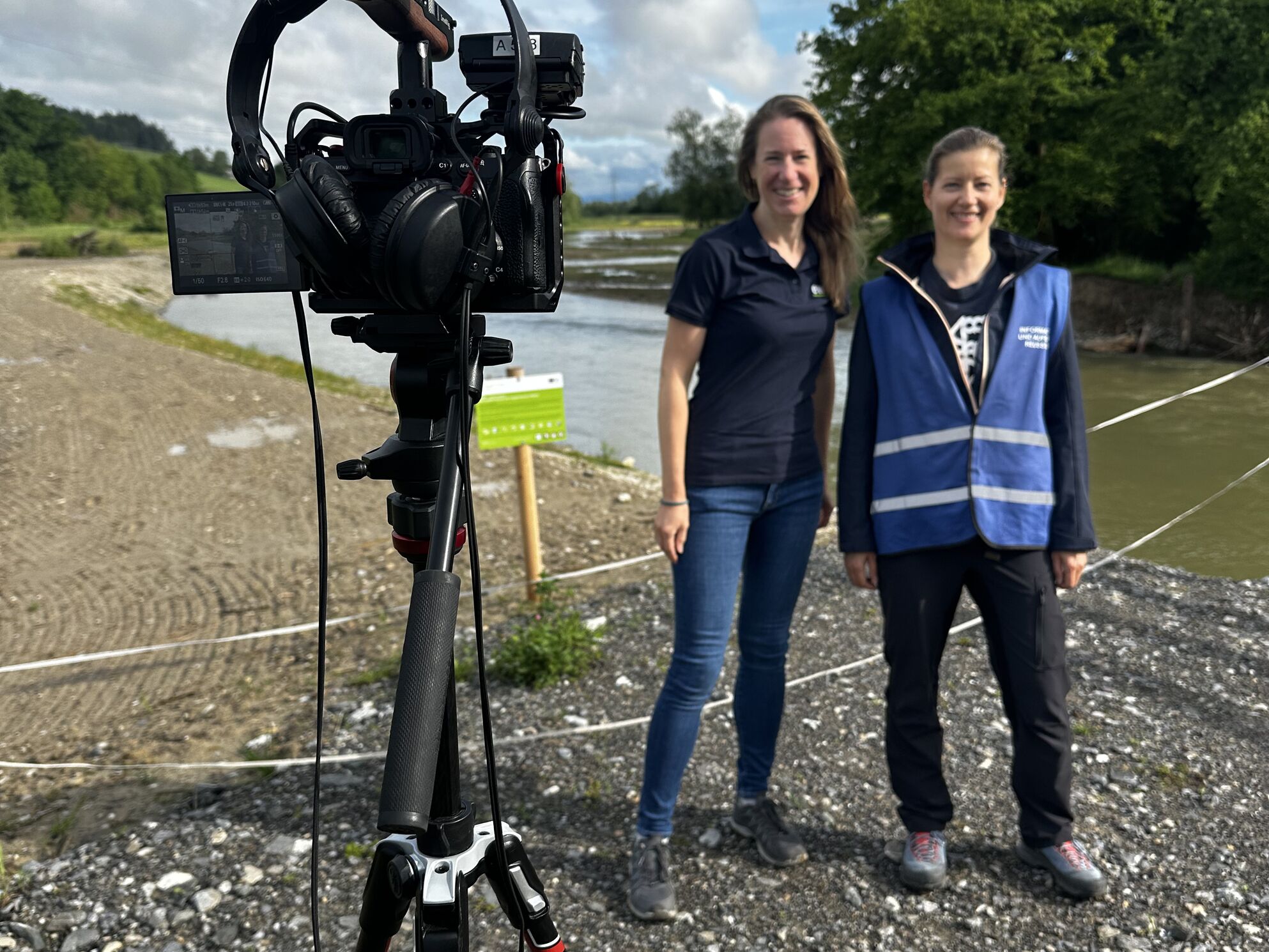 Nadine Hilker (EWZ) und eine Rangerin des Reussegg-Schutzgebiets vor der CORPMEDIA-Kamera – spontanes Statement-Interview beim Dreh für den naturemade Star-Fonds-Film über die Auenregeneration Reussegg.
