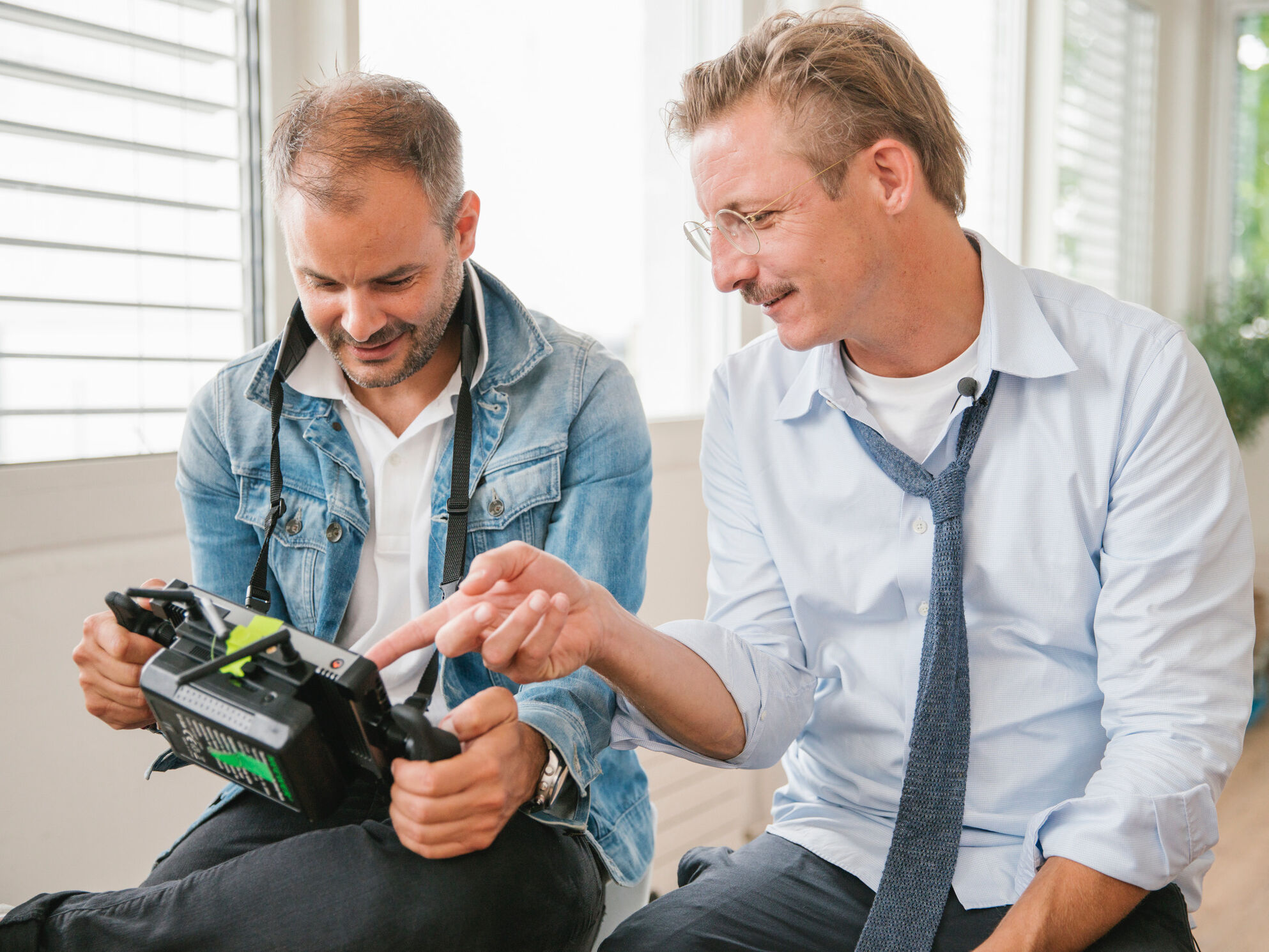 CORPMEDIA Gründer Timo Wäschle und Manuel Mazzoratti, CMO der Gehrig Gruppe, beim gemeinsamen Review am Regiemonitor während der Storyworld-Produktion mit Starköchin Meta Hiltebrand.