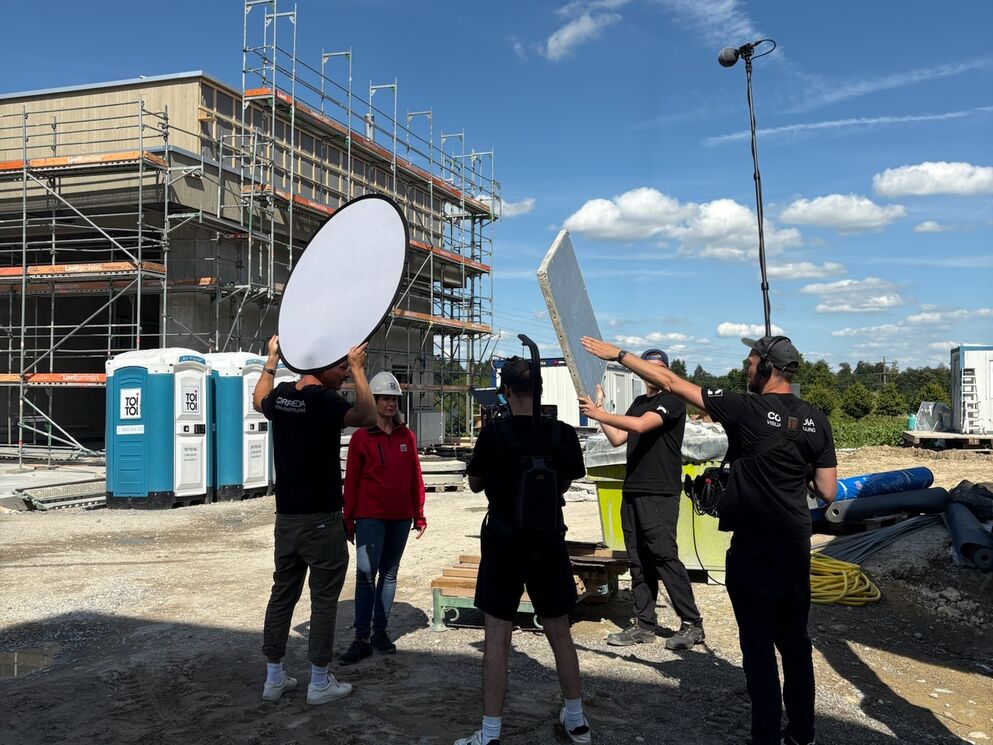CORPMEDIA Filmcrew mit Reflektor, Kamera und Tontechniker auf einer Schweizer Baustelle – Drehtag für den TOI TOI Case-Film über Leidenschaft, Verantwortung und 400'000 Kabinen im Einsatz.