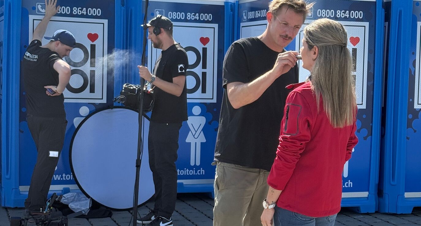 Timo Wäschle coacht, schminkt und bereitet Soraya Masino vor den TOI TOI Kabinen auf den Dreh vor – Make-up, Beruhigung und Kamera-Coaching gehören zum CORPMEDIA People-First-Ansatz.
