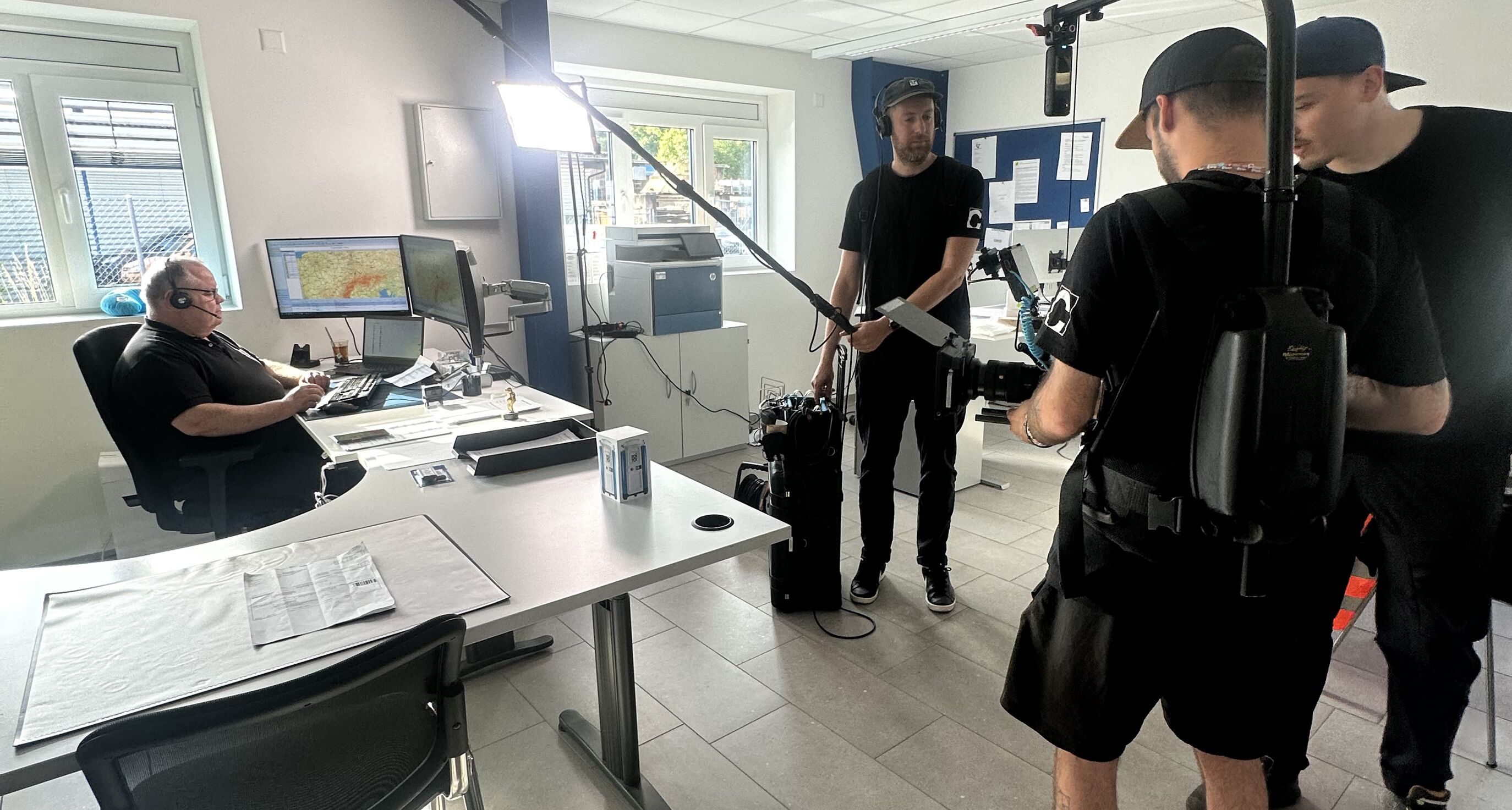 CORPMEDIA Filmcrew bei der Disposition im Büro – Vorbereitung des Drehtags für den TOI TOI Baustellen-Film.